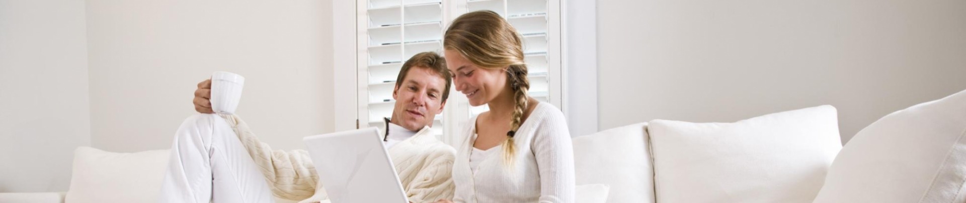 stelletje op de bank met laptop en koffie